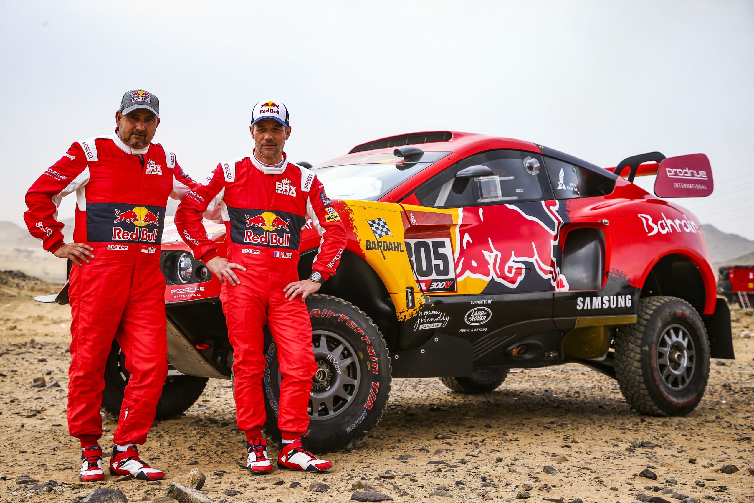 Co-Driver Daniel Elena and Driver Sébastien Loeb pose in front of their Prodrive Hunter rally car at the 2021 Dakar Rally in Saudi Arabia